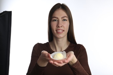 Photo of Smiling woman with tasty mochi on white background