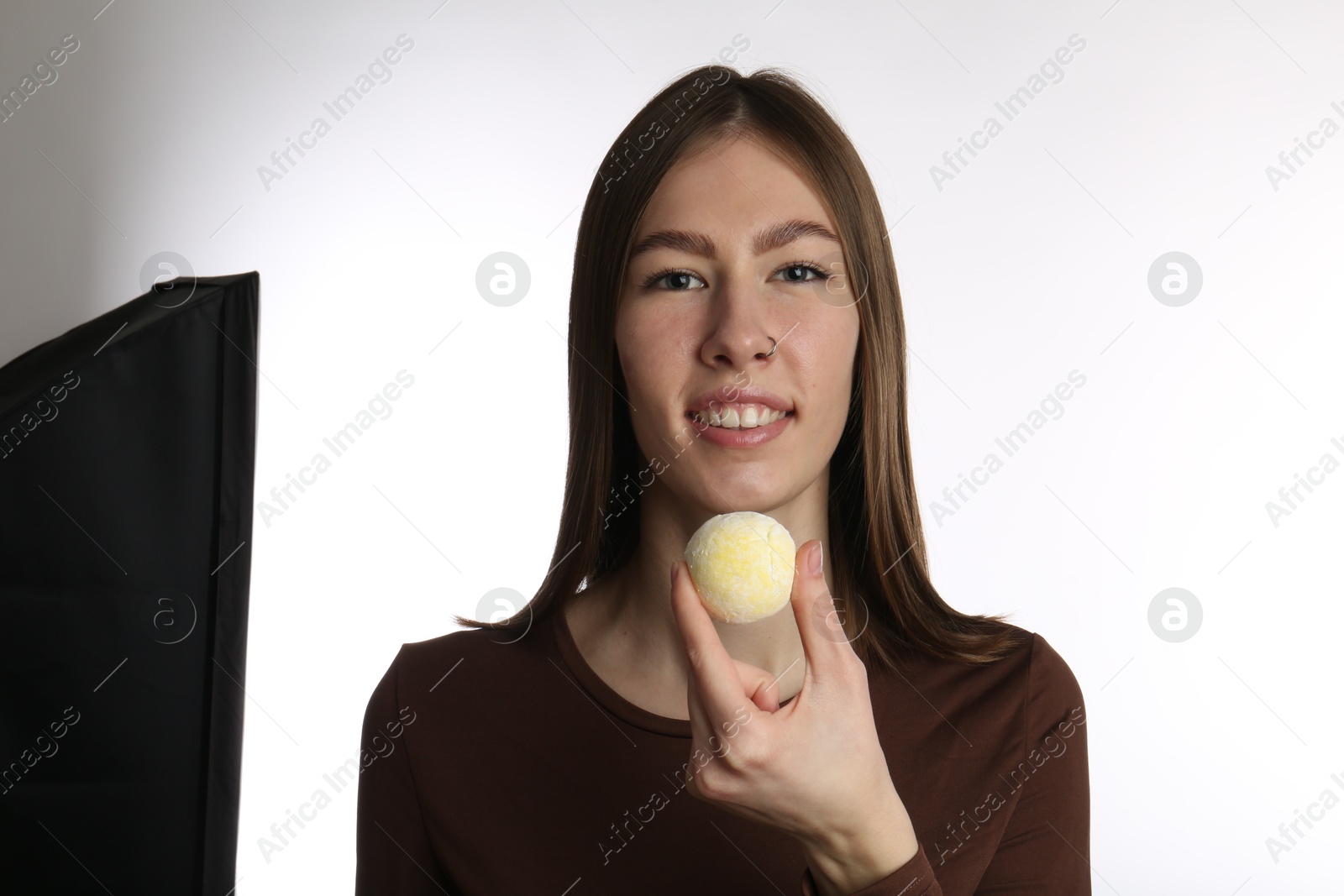 Photo of Smiling woman with tasty mochi on white background