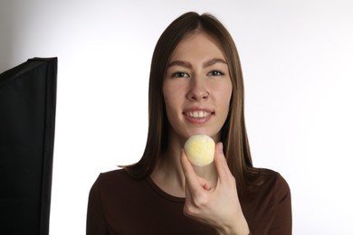 Photo of Smiling woman with tasty mochi on white background