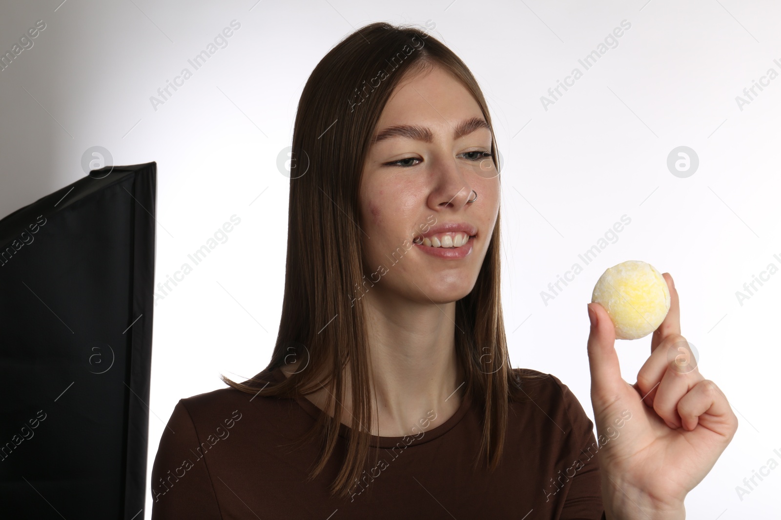 Photo of Smiling woman with tasty mochi on white background