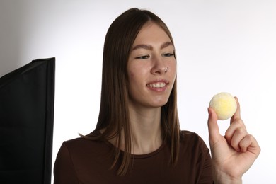 Photo of Smiling woman with tasty mochi on white background