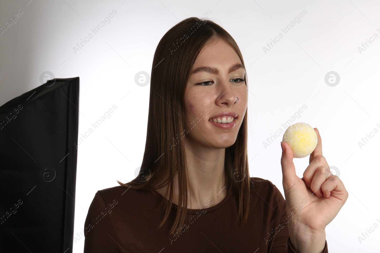 Photo of Smiling woman with tasty mochi on white background