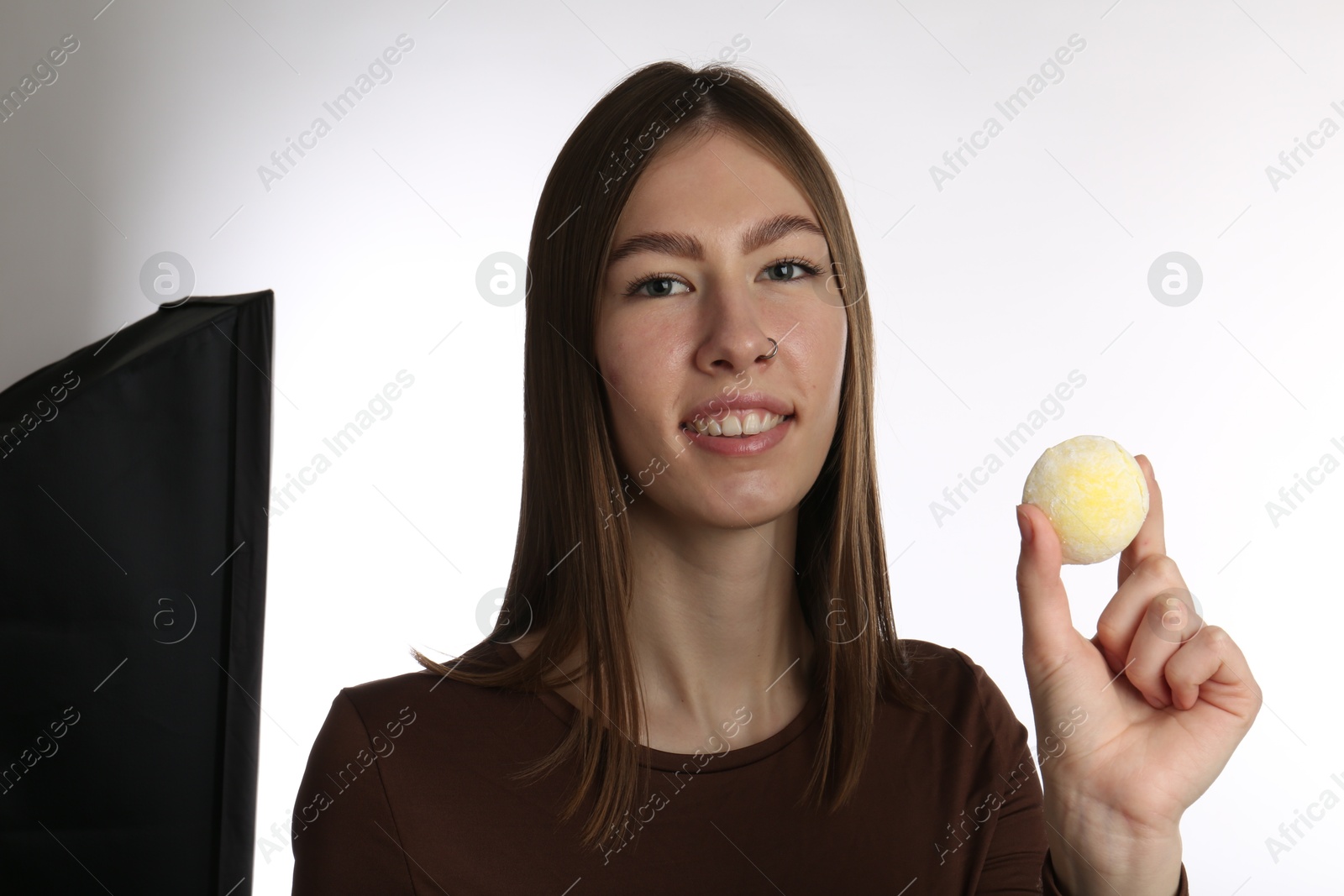 Photo of Smiling woman with tasty mochi on white background