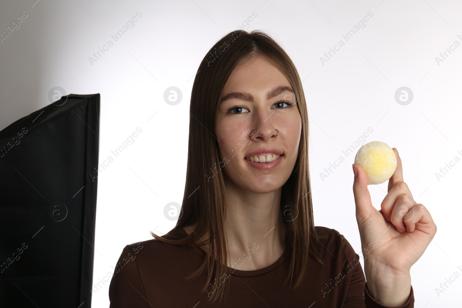 Photo of Smiling woman with tasty mochi on white background