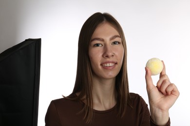 Photo of Smiling woman with tasty mochi on white background