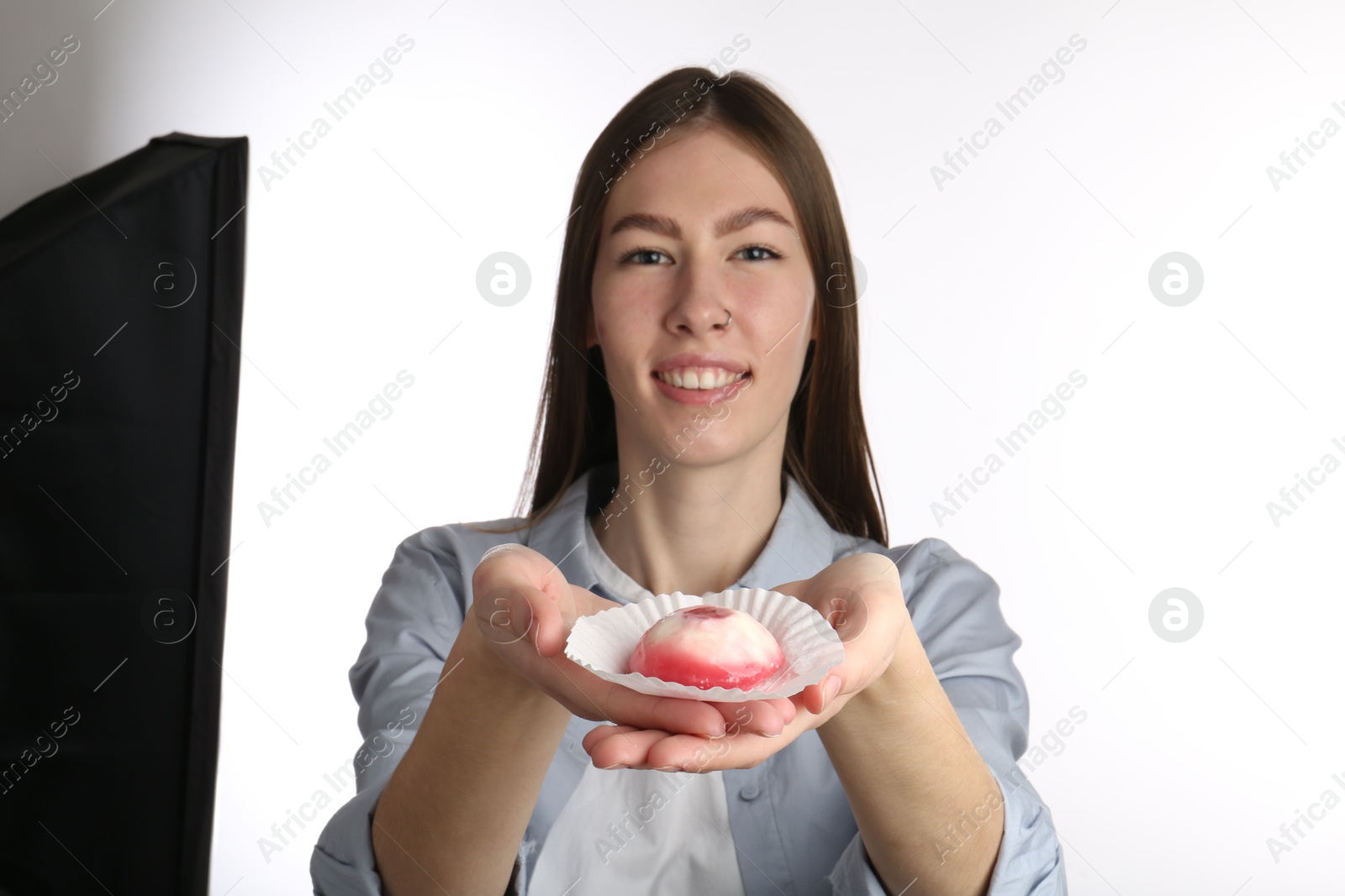 Photo of Smiling woman with tasty mochi on white background