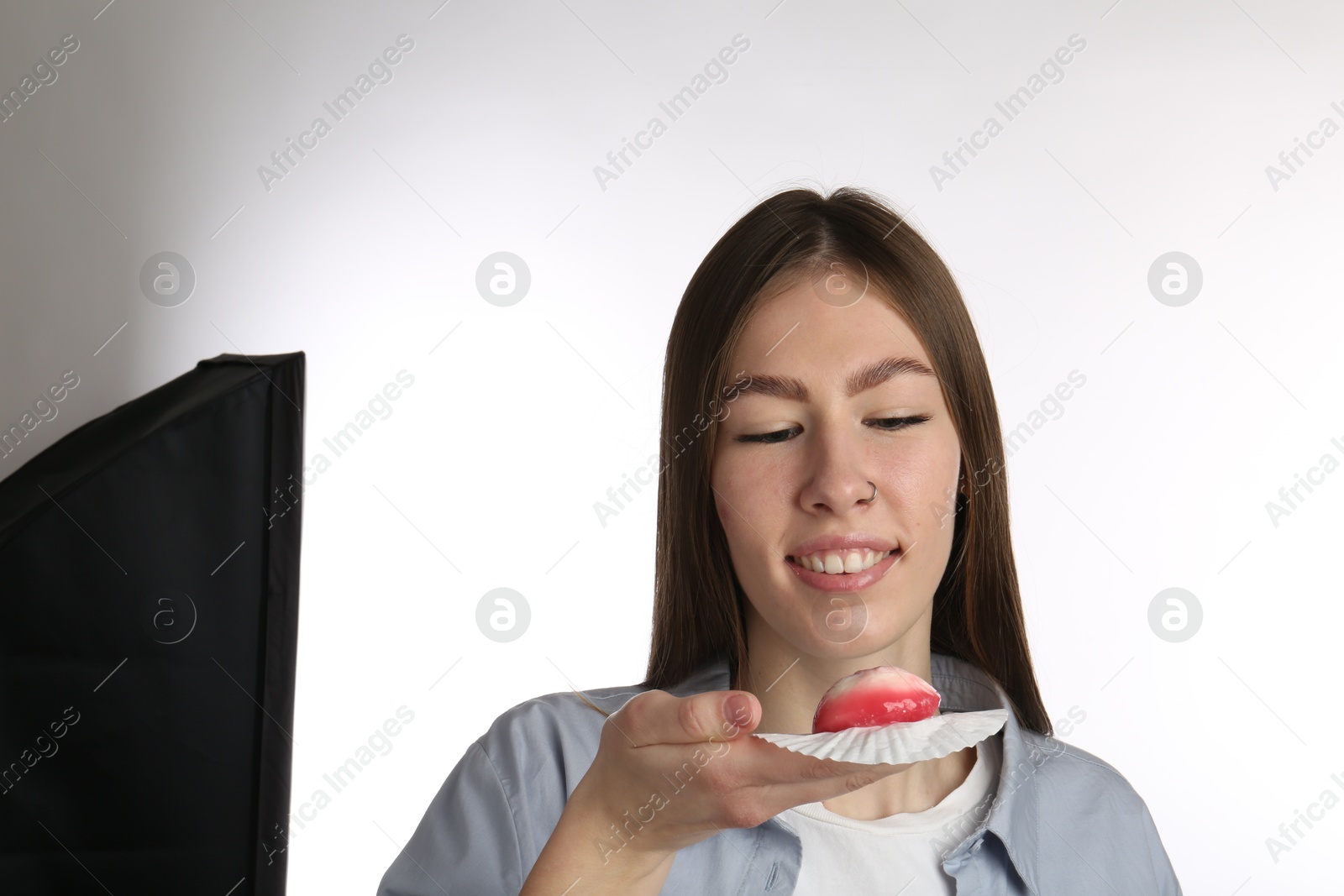 Photo of Smiling woman with tasty mochi on white background