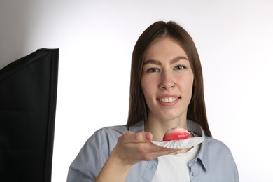 Photo of Smiling woman with tasty mochi on white background