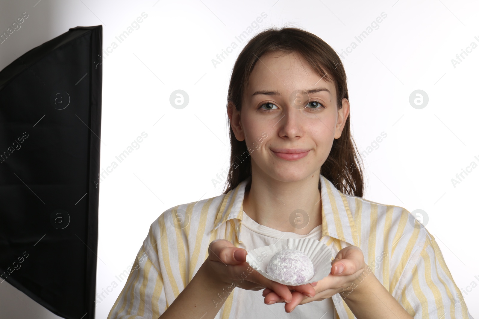 Photo of Beautiful woman with tasty mochi on white background