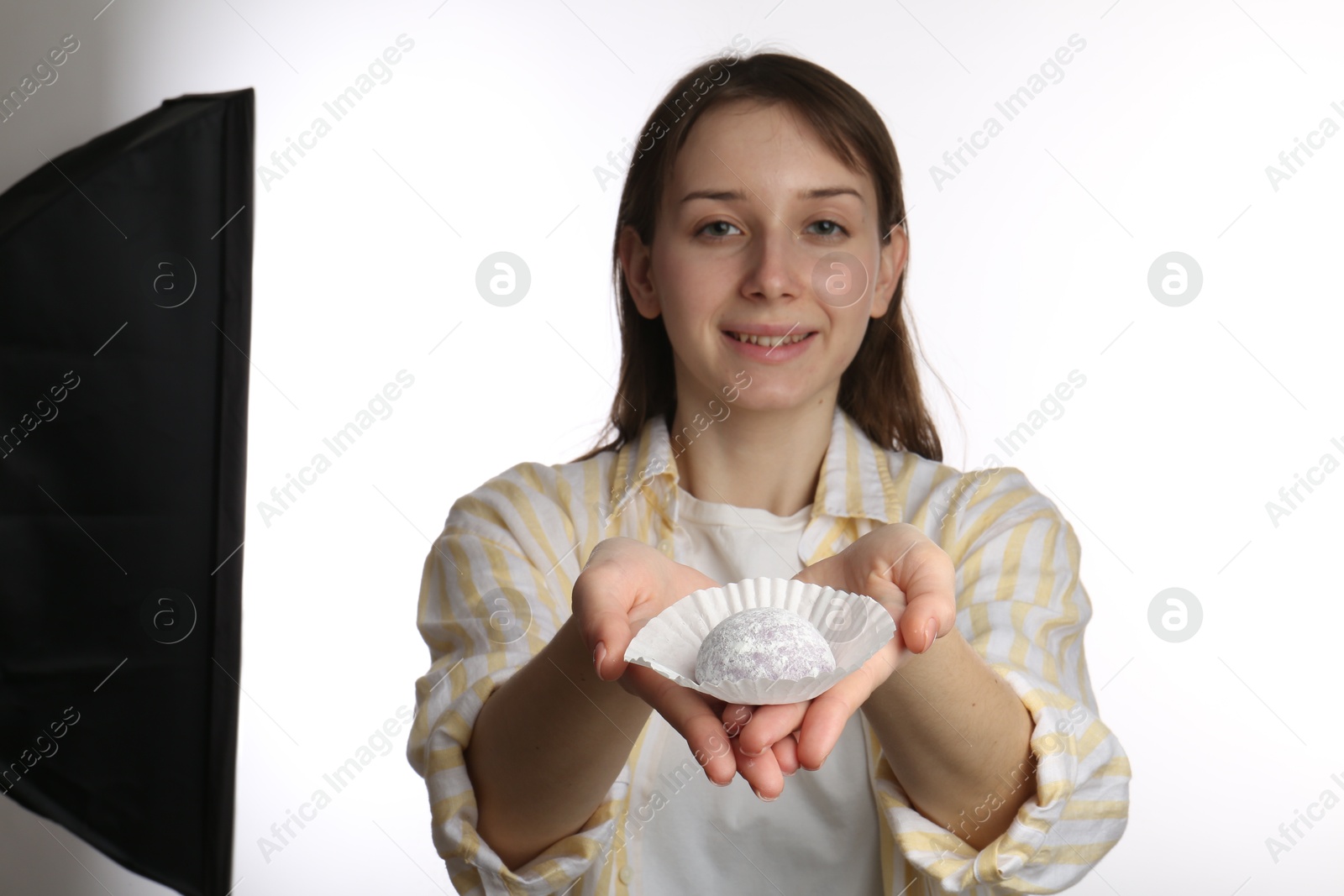 Photo of Smiling woman with tasty mochi on white background