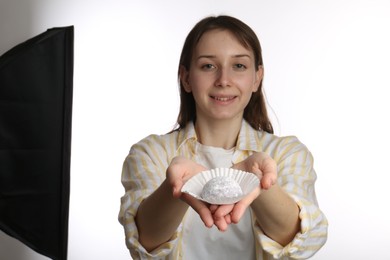 Photo of Smiling woman with tasty mochi on white background