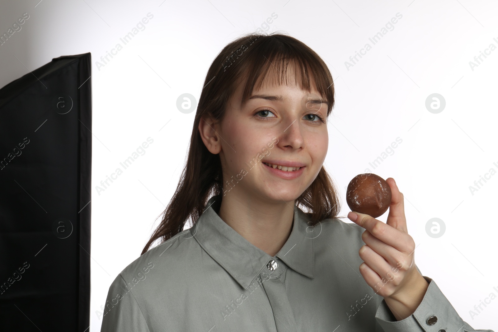 Photo of Smiling woman with tasty mochi on white background