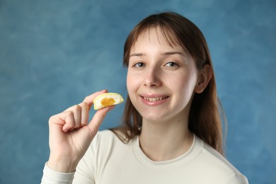 Photo of Smiling woman with tasty mochi on blurred blue background