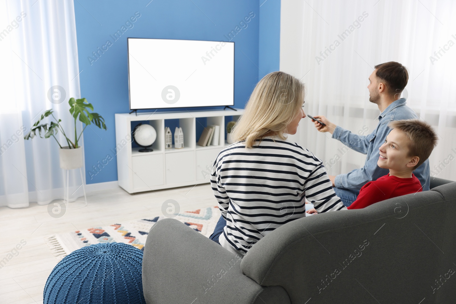 Photo of Happy family watching tv together at home