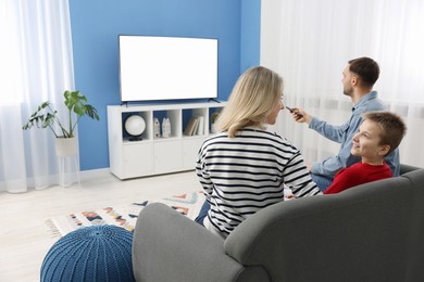 Photo of Happy family watching tv together at home