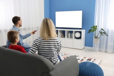 Photo of Happy family watching tv together at home