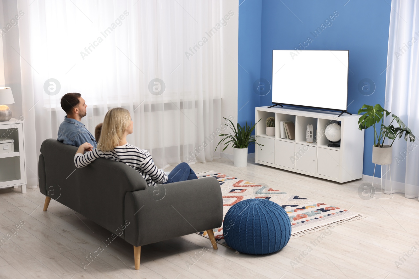 Photo of Happy family watching tv together at home