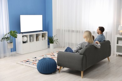 Photo of Happy family watching tv together at home