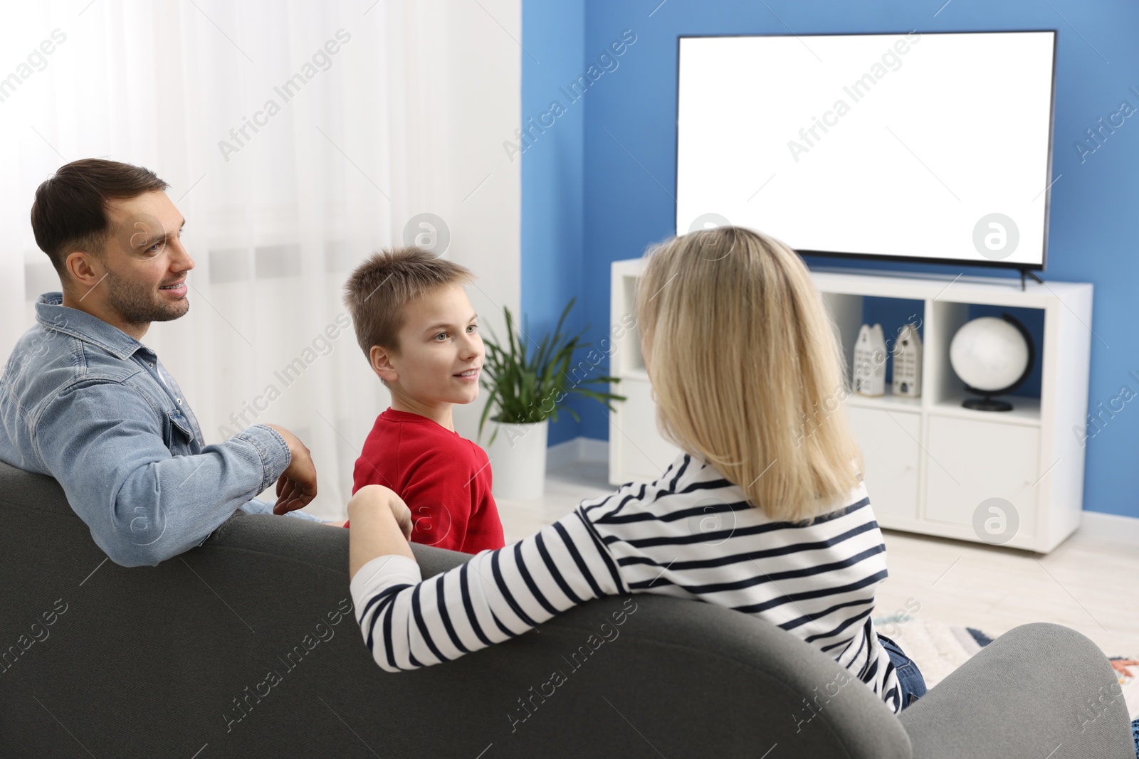 Photo of Happy family watching tv together at home