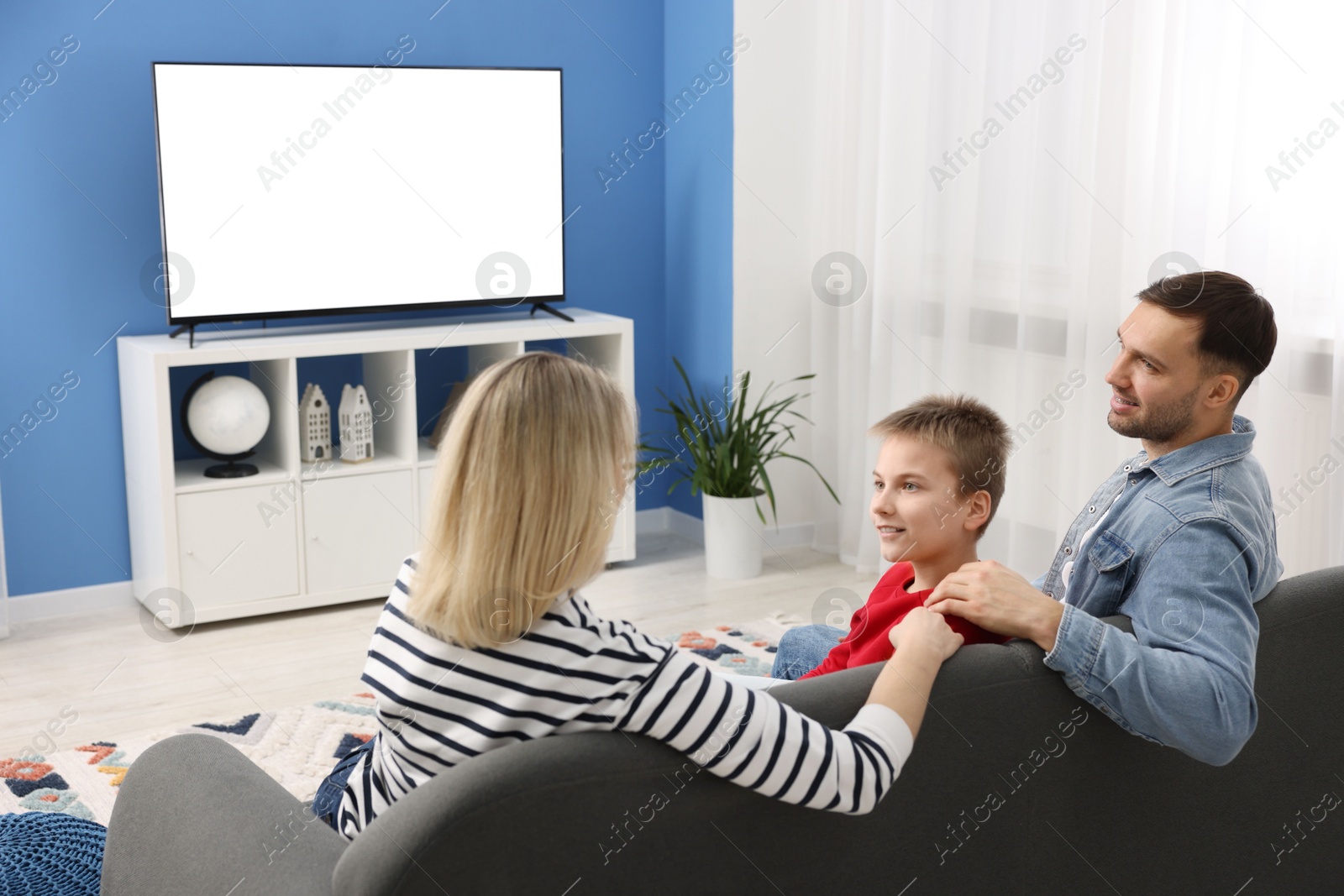 Photo of Happy family watching tv together at home