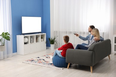 Photo of Happy family watching tv together at home