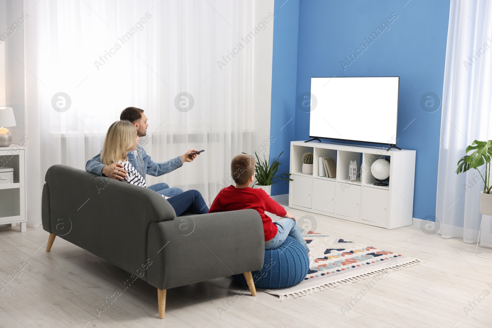 Photo of Happy family watching tv together at home