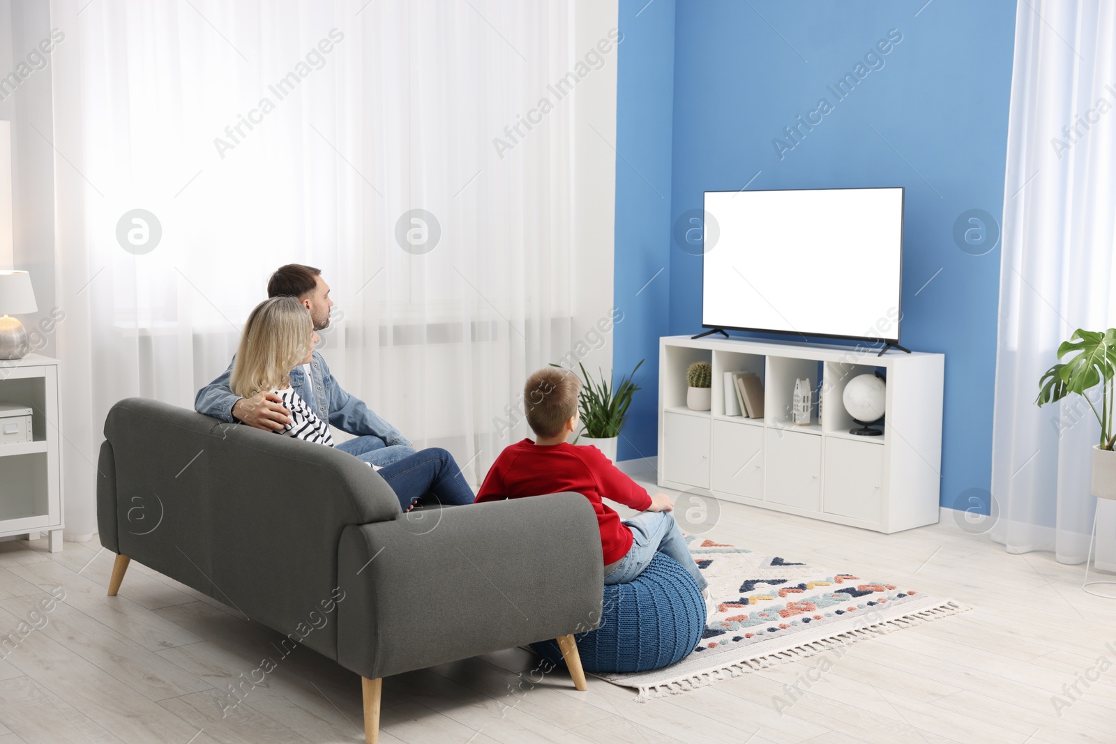 Photo of Happy family watching tv together at home