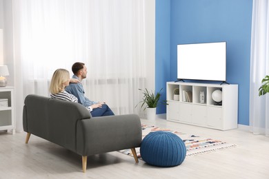 Photo of Lovely couple watching tv on couch at home