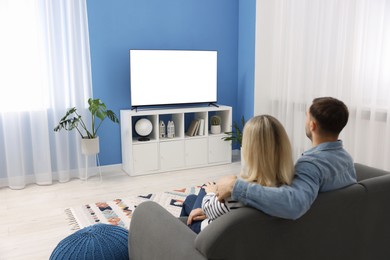 Photo of Lovely couple watching tv on couch at home