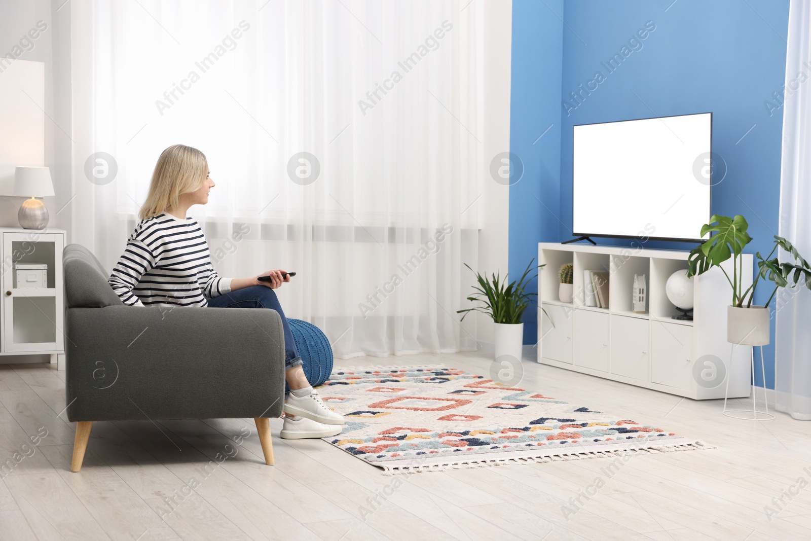 Photo of Woman watching tv on couch at home