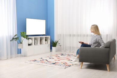 Photo of Woman watching tv on couch at home