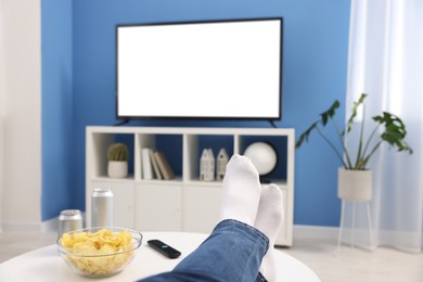 Photo of Woman with snacks and drinks watching tv at home, closeup