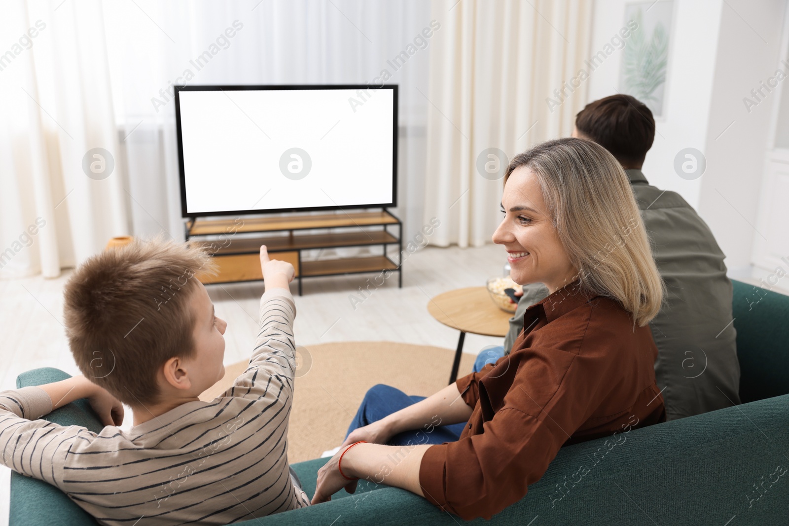 Photo of Happy family watching tv together at home