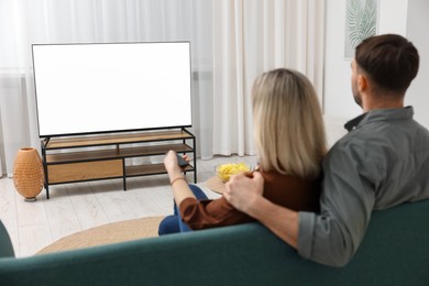 Photo of Lovely couple watching tv on couch at home, back view