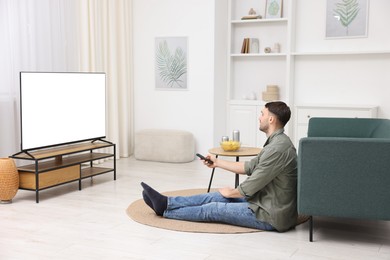 Photo of Man watching tv on floor at home