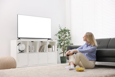 Photo of Woman with chips watching tv at home