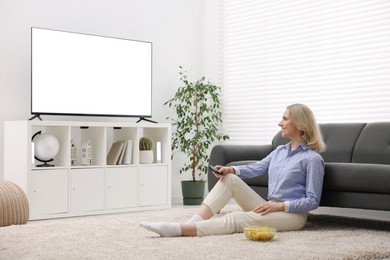 Photo of Woman with chips watching tv at home