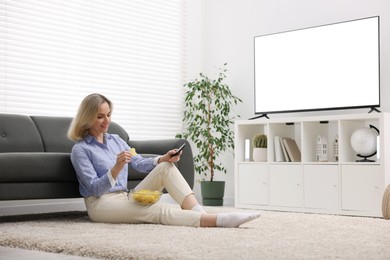 Photo of Woman with chips watching tv at home