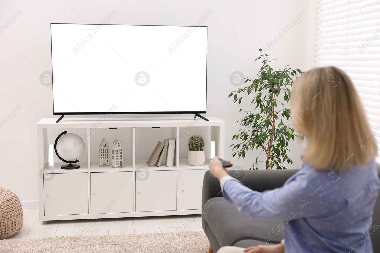 Photo of Woman watching tv on couch at home