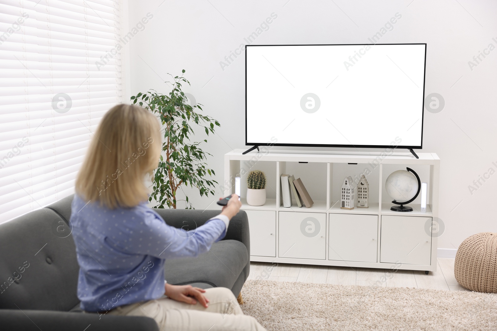 Photo of Woman watching tv on couch at home