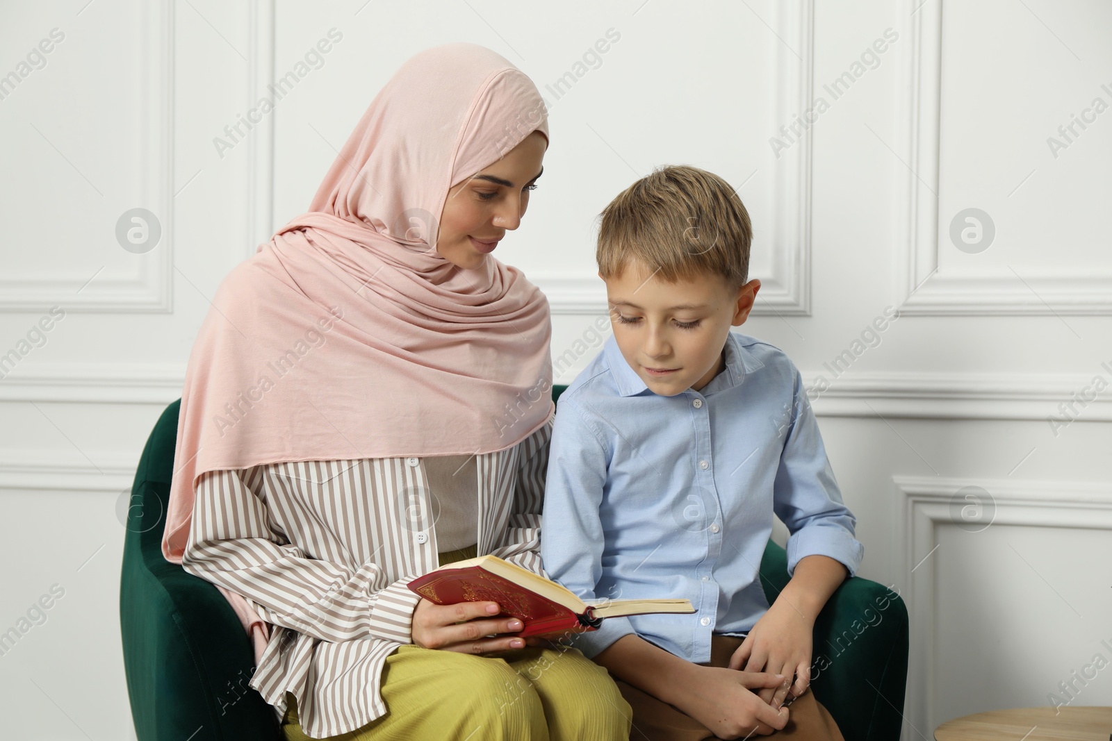 Photo of Muslim woman and her son spending time together at home