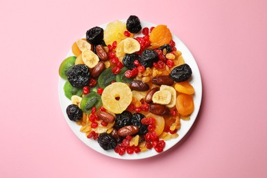 Photo of Mix of different dried fruits on pink background, top view