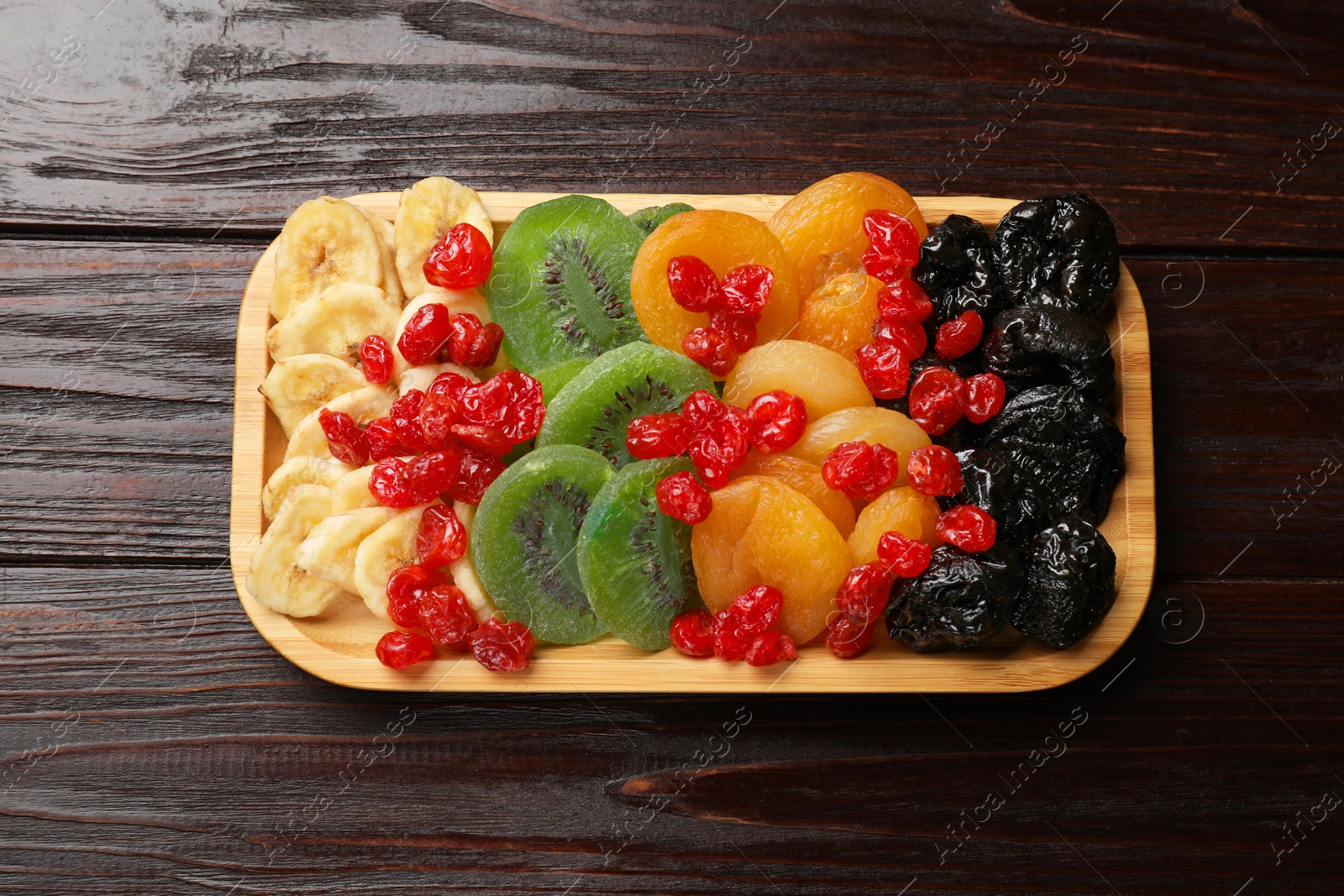 Photo of Different dried fruits on wooden table, top view