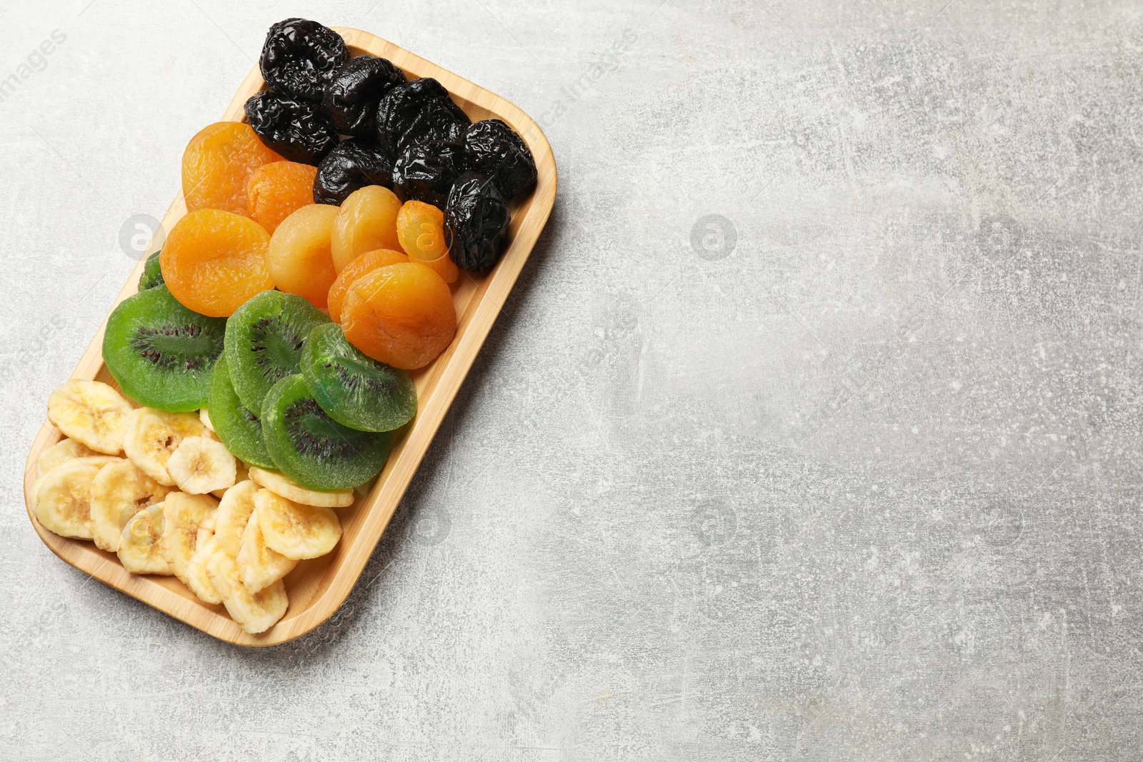 Photo of Different dried fruits on grey table, top view. Space for text