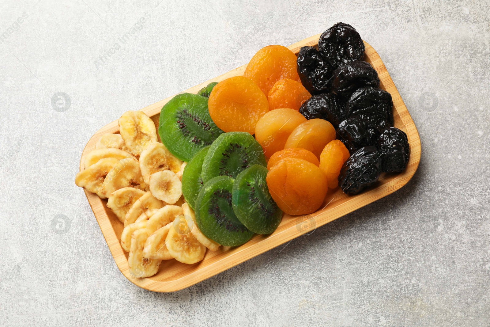 Photo of Different dried fruits on grey table, top view