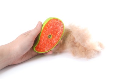 Photo of Woman holding grooming brush with pet's hair on white background, closeup