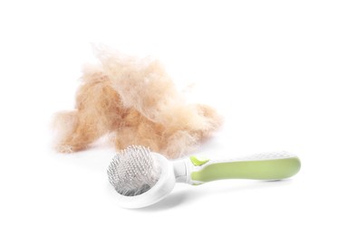 Photo of Grooming brush and pile of pet's hair isolated on white