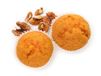 Photo of Tasty sweet carrot muffins and walnuts isolated on white, top view