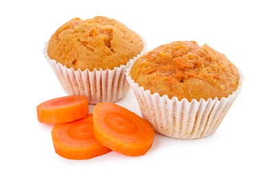 Photo of Tasty sweet carrot muffins and cut vegetable isolated on white