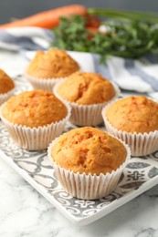 Photo of Tasty carrot muffins on white marble table, closeup